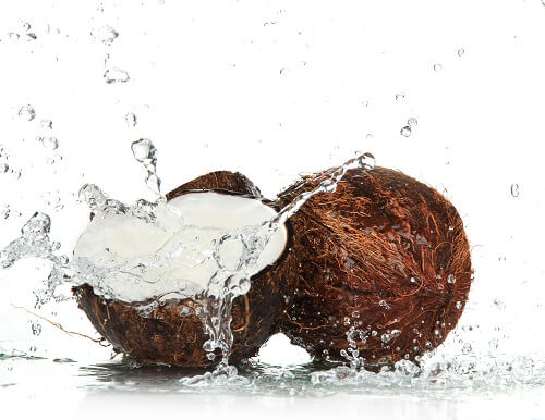 Cracked coconut with splashing water.
