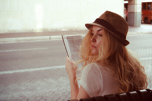 Woman sitting on a bench with long hair reading hair grow