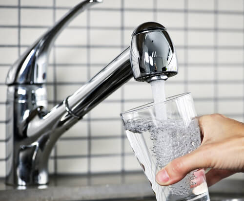 Someone filling a glass of water