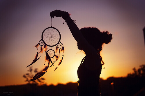 Woman holding a dream cacther in the wind