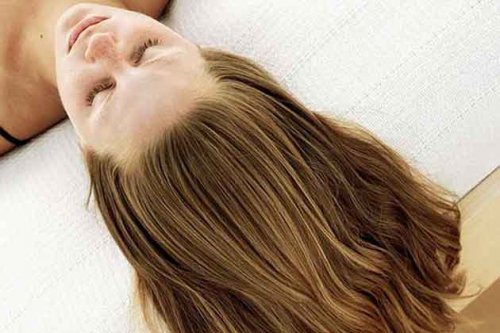 Woman lying down showing her very healthy moisturized hair treatments with apple cider vinegar