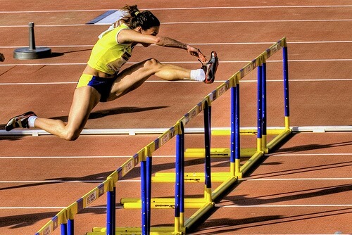 A woman jumping hurdles