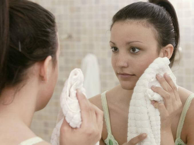 Woman drying her face with a towel