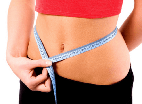 woman measuring her stomach with a tape measurer