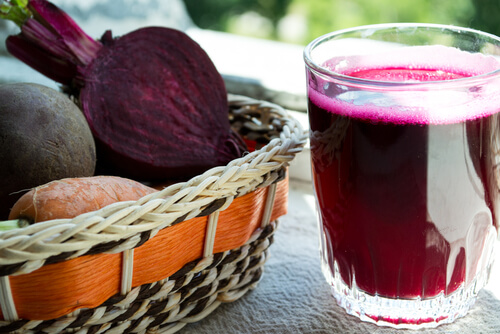 Basket with beets and glass of beet juice on a table