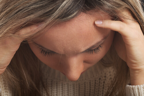 woman with emotional problems holding her head