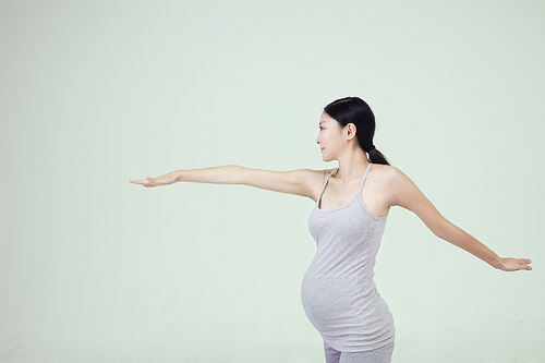 Pregnant woman with arms stretched out