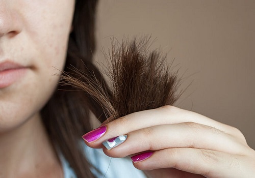 Woman holding dry ends of her hair