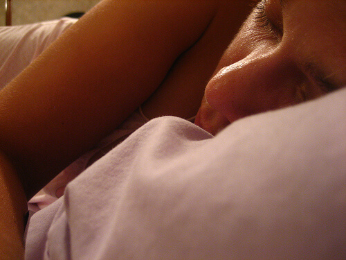 A woman sleeping on her side.