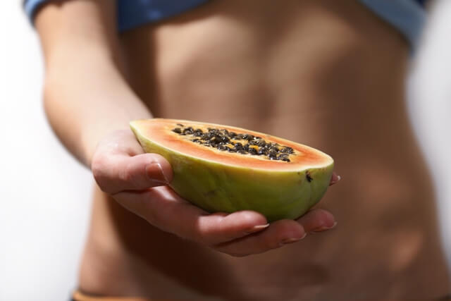 Woman holding half a papaya