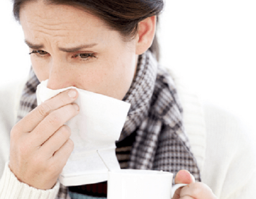 Woman blowing her nose in a tissue
