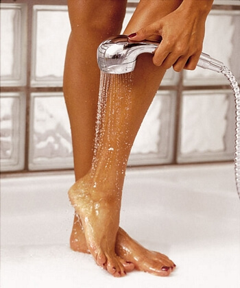 Someone washing their legs with warm water to prevent ingrown hairs