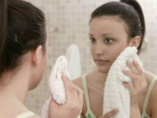 Woman drying face with towel get rid of acne scars