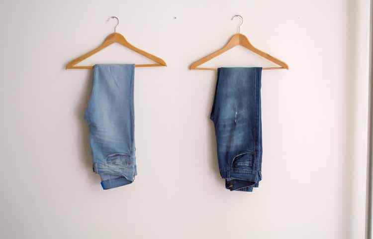 Jeans hanging on hangers.