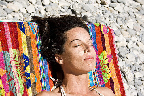 Woman sunbathing on a pebble beach strengthen your immune system