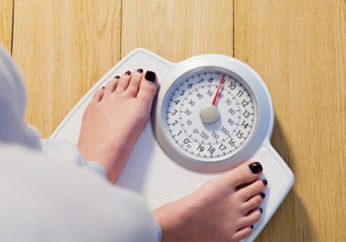 woman on scale trying to lose weight with aloe vera