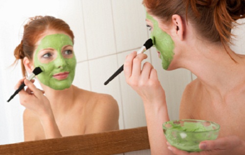 woman applying a clay mask