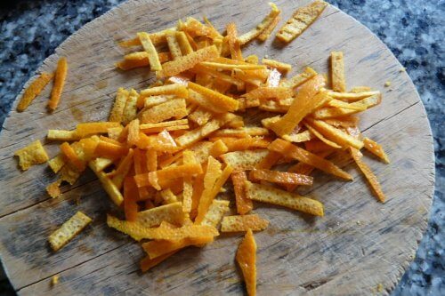 Dried orange peel strips on wooden surface