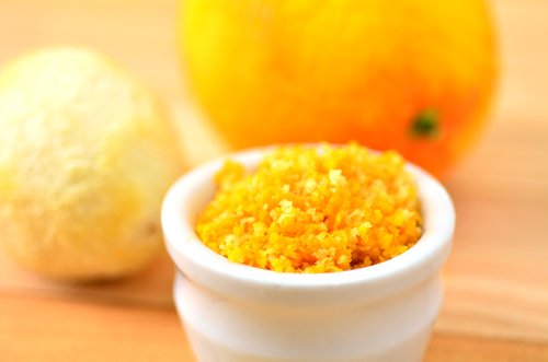 Bowl of orange zest with orange in background