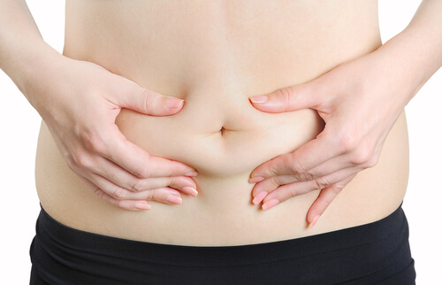 A person squeezing their abdominal fat.