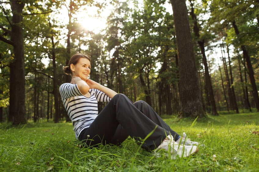 A woman exercising in the forest.