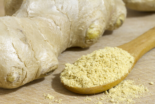 Ginger root and powdered ginger in a spoon
