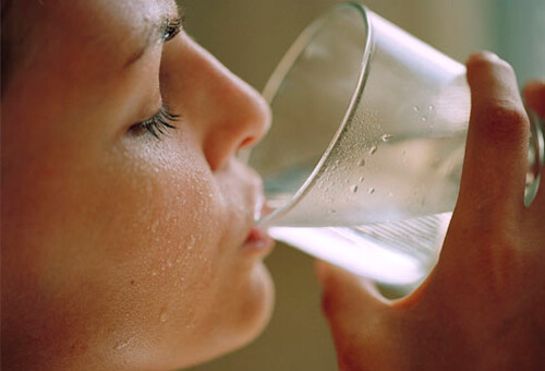 A woman drinking water.