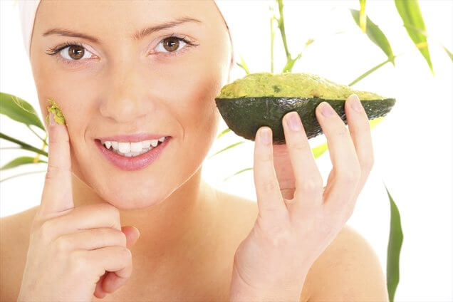 Woman applying an avocado mask