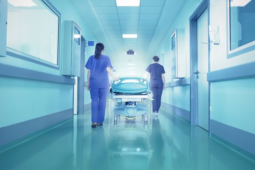 Two medical professionals walk down a hall in a hospital mortality rate of ebola virus