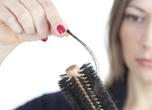 Woman pulling hair off of brush
