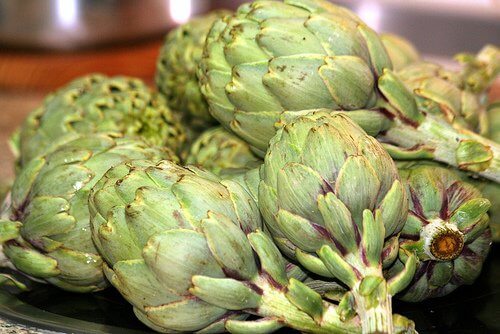 Bunch of artichokes sitting on a table