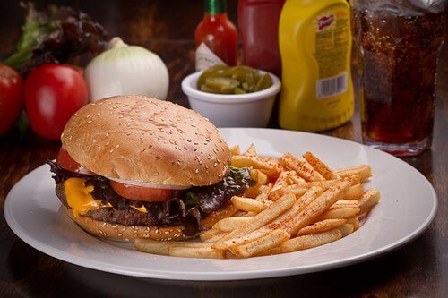 A burguer next to some french fries