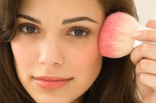 Woman putting on makeup to make her face look thinner