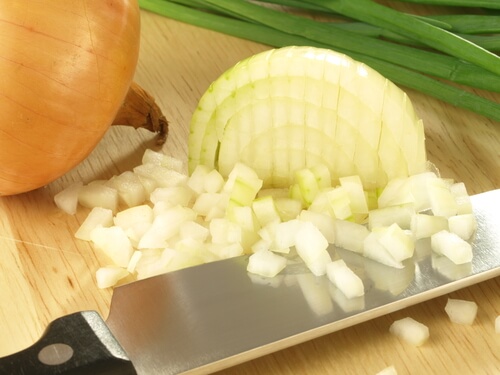 A knife with some diced onion.