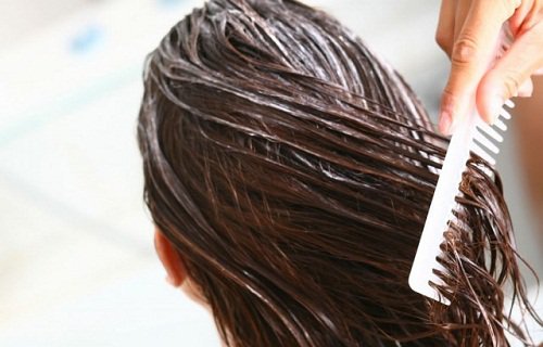 A woman applying a hair mask.