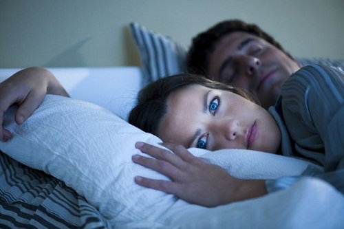 Couple in bed man asleep woman awake sleep poorly