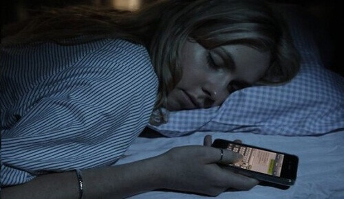Woman sleeping with cell phone in hand sleep poorly night