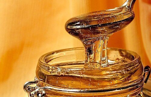 Glass jar of honey with spoon