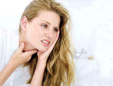 Kvinne med sår hals prøver behandlinger for halsinfeksjoner