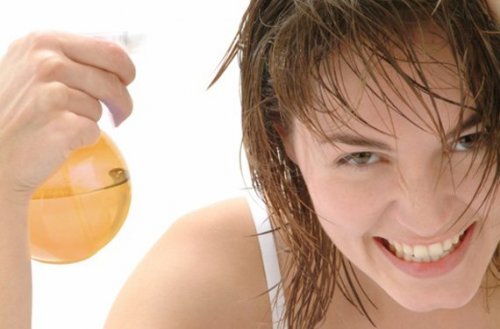 Woman with spray bottle applying product smiling ways to lighten your hair