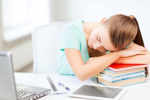 Girl taking a nap on top of her books