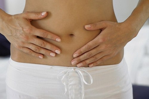 Woman with flat stomach touching her belly foods you should never eat