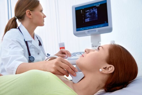 Doctor checking a woman for thyroid problems
