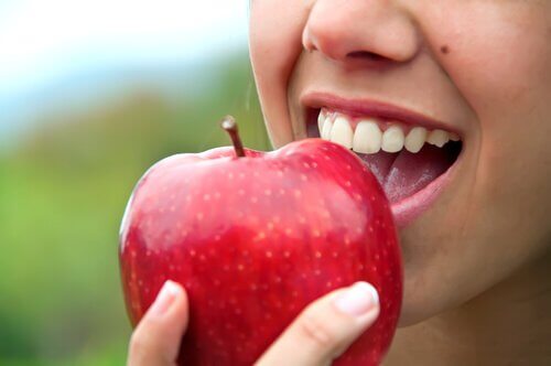 Woman eating red apple
