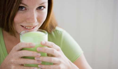 Woman drinking smoothie made with artichokes 
