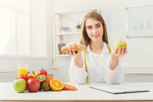 A doctor holding fruits to include in the diet other than an orange.