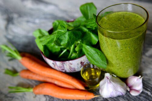 A glass of spinach and carrot smoothie