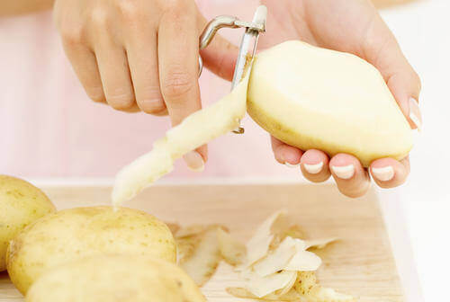 Person peeling potatoes for perfect mashed potatoes