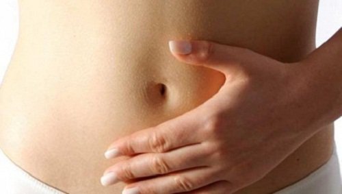 A person with a hand on their stomach because they are having stomach problems