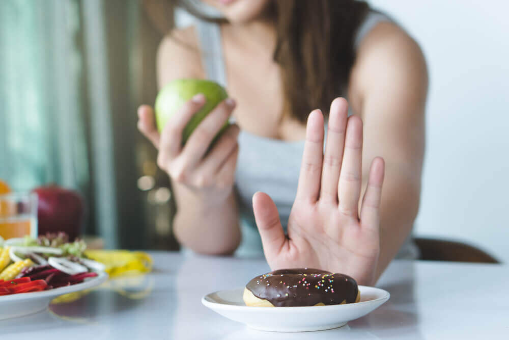 A woman rejecting a donut.